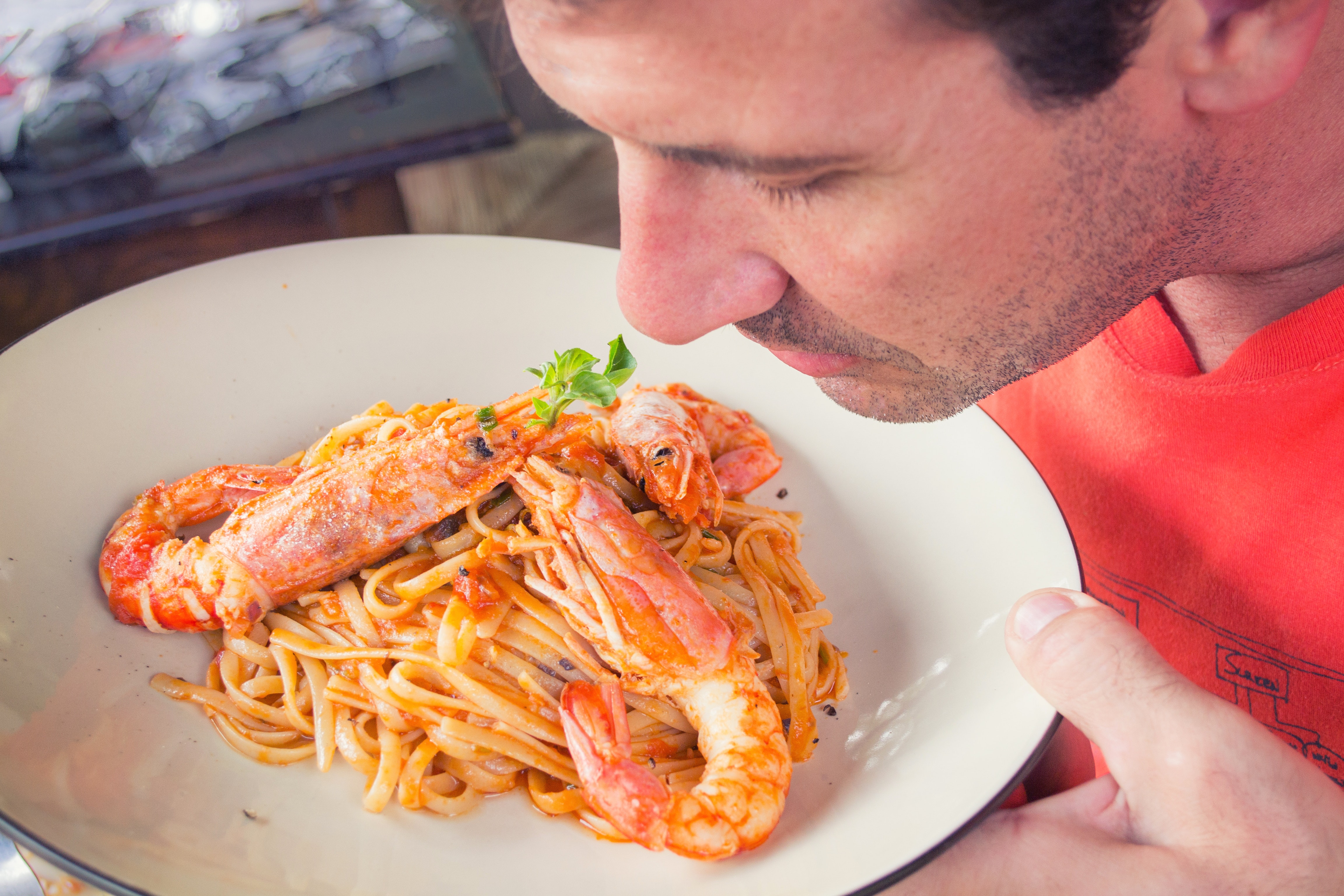 man smelling a seafood dish