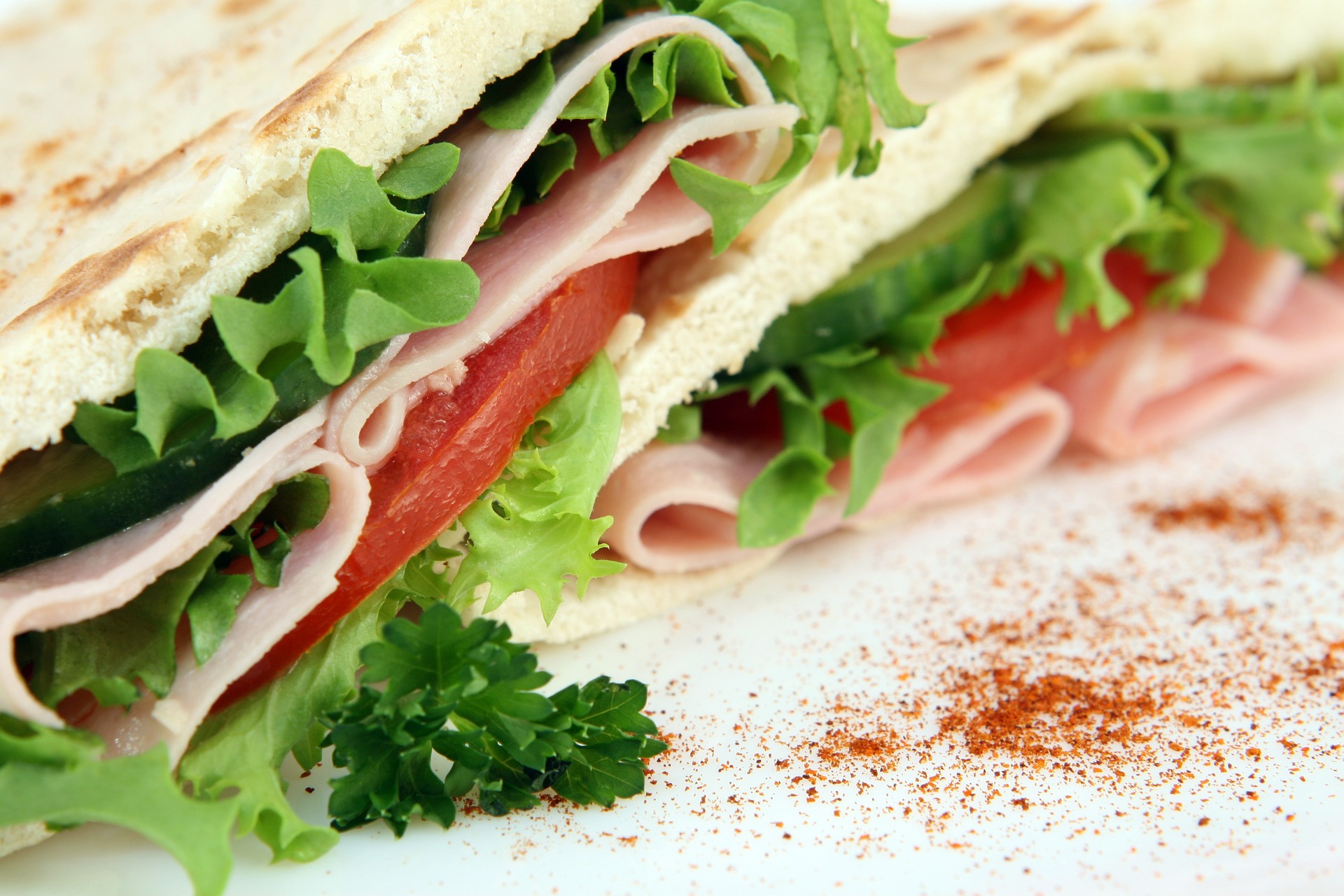 close up of a sandwich with lettuce, tomatoes and deli meat