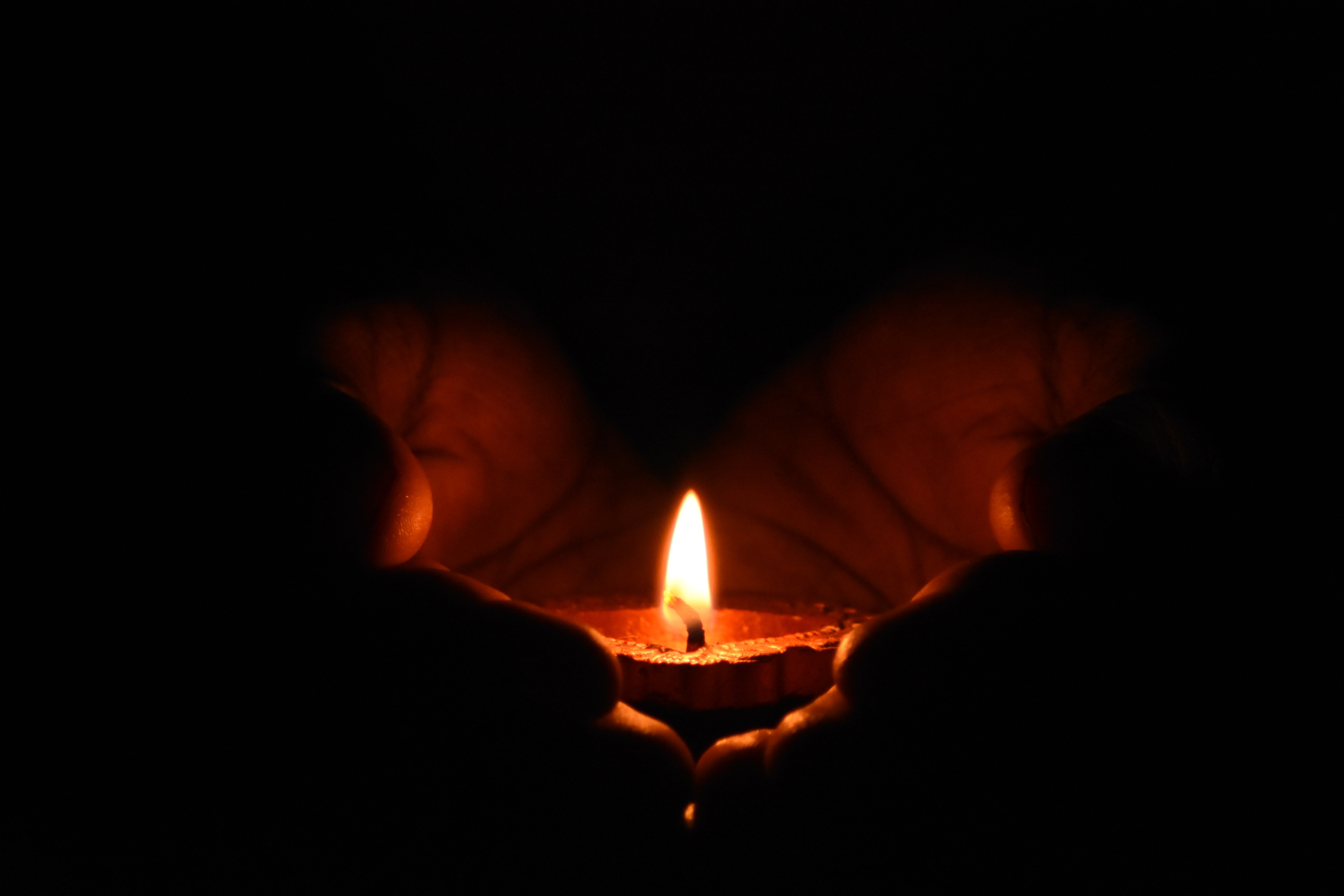 hands holding a tea light candle