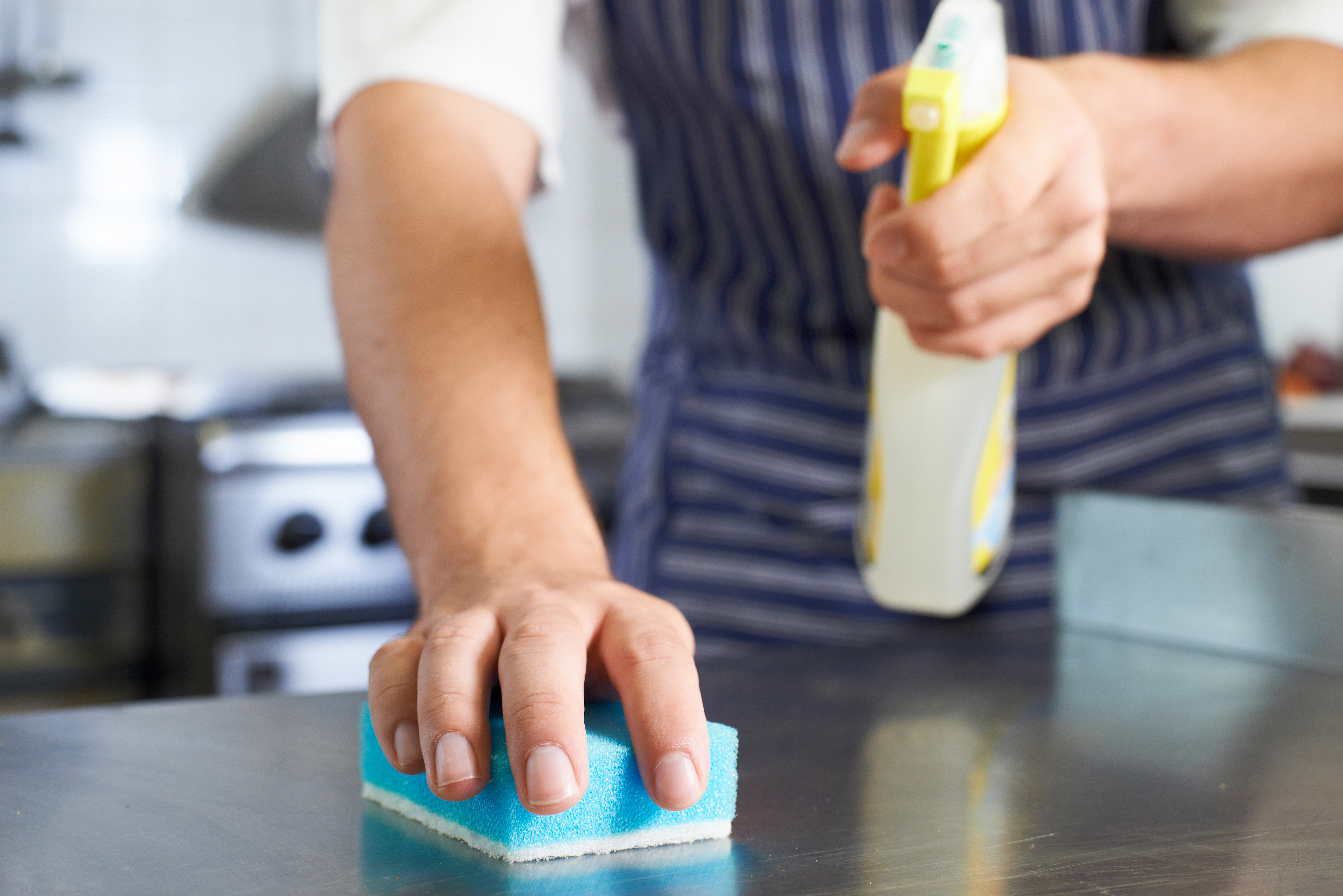foodservice worker cleaning and sanitizing a counter