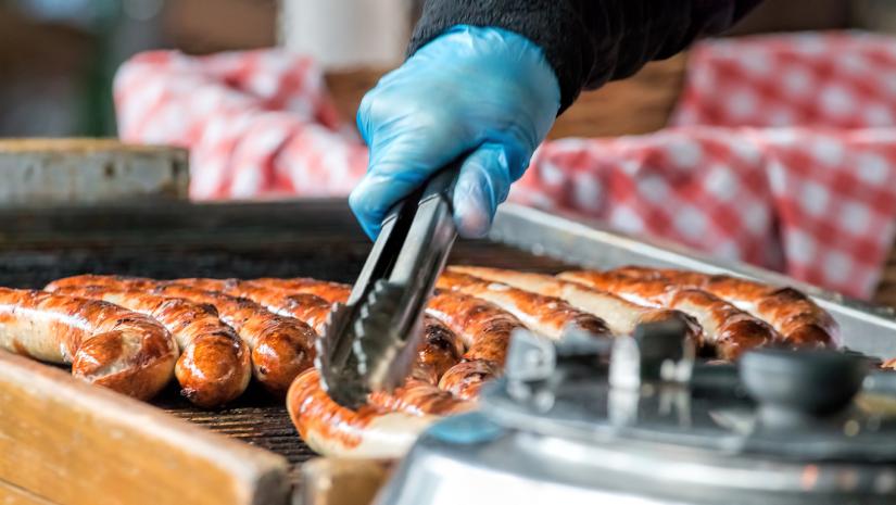 Hands with tongs and sausages
