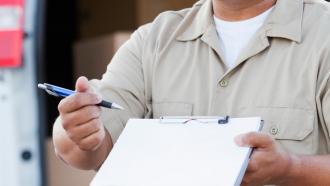 Delivery driver holding checklist for food delivery to restaurant