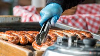 Hands with tongs and sausages