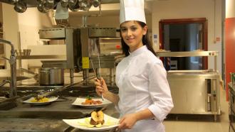 young female chef preparing food in a restaurant
