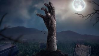 Zombie hand rising in dark Halloween night