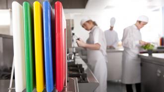 kitchen staff standing behind multi-coloured cutting boards in a restaurant