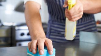 foodservice worker cleaning and sanitizing a counter