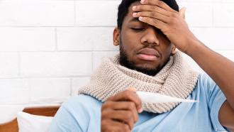 Man taking body temperature with thermometer