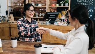 A hiring manager and new employee shaking hands after an interview.