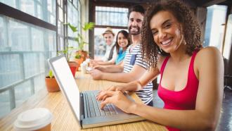 Woman sitting in front of a laptop, excited about training.